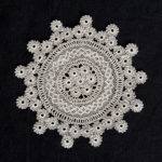 41. Lace Doily-Cotton Collection of the Armenian Museum of America in Boston, MA 1987.059.1 Gift of William Chaderjian Small, circular, needle lace doily. Center is made of combing seven small rosettes together, radiating rows of broomstick stitches and netted filled stitching. Edged with small rosettes stitched together to make a triangular rim. Very fine thread and delicate stitching.