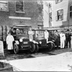 59. KALASHIAN_George_2-84-The three Kalashian brothers, Sam, Sarki and George (pictured to the far right) are shown with their employees in front of the Velevet Ice Cream Manufacturing Plant delivery cars,1921. Photographer unknown. The Velvet Ice Cream Manufacturing plant was in business from 1920-1957 in Worcester, MA.