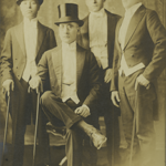 62. NAHABEDIAN_Walter_4-04-Yeghia Yavanian stands in the middle with his friends, names unknown; Boston area, early 1900s; photographer unknown. In their formal attire, these gents catch the light with their black-satin high toppers (top hats also called "stove pipes") with 6"-7" tall crowns.